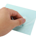 Hand removing protective film from clear polycarbonate welding helmet replacement lens, 138 x 122mm, for safe use.