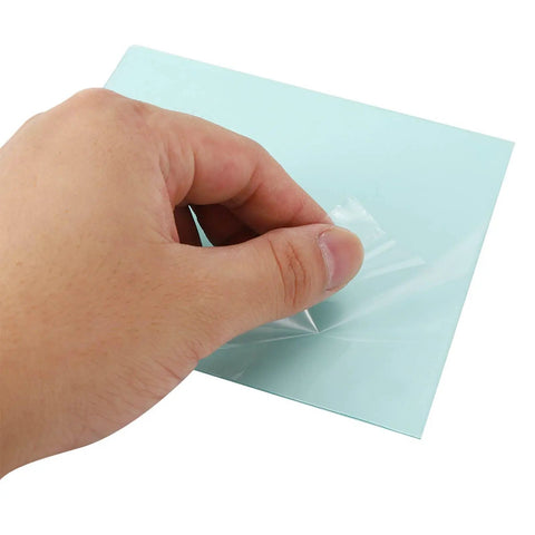 Hand removing protective film from clear polycarbonate welding helmet replacement lens, 138 x 122mm, for safe use.