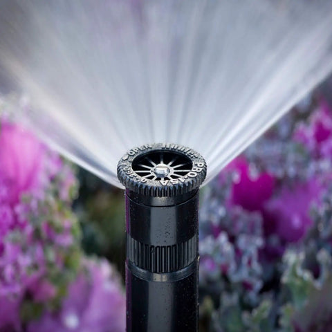 Adjustable Spray Nozzle With 0 To 360 Degree Arc And 15 Ft Radius Delivers Precise Pop Up Sprinkler Performance For Lawn And Landscape Irrigation With Even Coverage And Water Savings No Fuss Setup spraying water over plants
