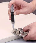 Heavy Duty Badass Automatic Center Punch Tool used on metal hinge for precise marking on wooden surface.