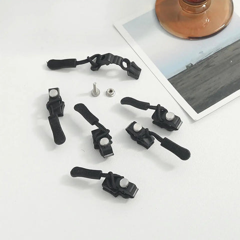 Universal Zipper Repair Kit With Removable Sliders And Quick Fix Heads, showing black adjustable zipper pulls and components on table.