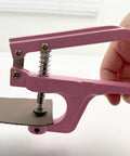 Close-up of pink pliers installing a metal snap on leather, part of 50 Sets Metal Snap Buttons Kit With Pliers 15mm Leather Snap Fasteners.