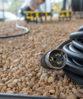 Heavy Duty 50 Amp Generator Extension Cord 100 Feet Jobsite Power Distribution Splitter with twist lock end on gravel surface.