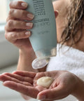 Quick Fix Leave In Hair Treatment Infuses Damaged Strands With Hella Hydration And Serious Shine For A Silky Smooth Finish Before Your Daily Blowout Session being dispensed onto a hand.
