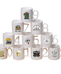 White mugs with geocaching vinyl decals in a pyramid, showcasing designs part of 50 Piece Waterproof Geocaching Stickers Pack Vinyl Decals For Water Bottles Laptops Luggage Bicycles Skateboards Computers And More Rad Adventure Gear Decor.