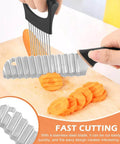 Black stainless steel crinkle cutter with a wavy blade and handle slicing carrots on a wooden board