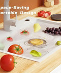Cordless Electric Produce Washer And Veggie Scrubber Driven By Smart Electrolytic Tech cleaning fruits in a kitchen sink.