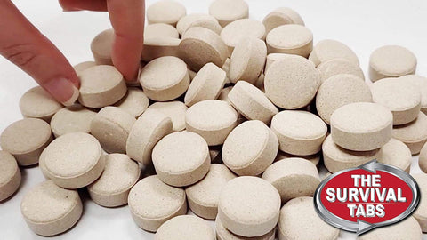 Hand selecting tablets from a pile with logo, 180 Tabs Emergency Food Supply, 15 Day Survival Meals, Gluten Free Non GMO MRE Style.