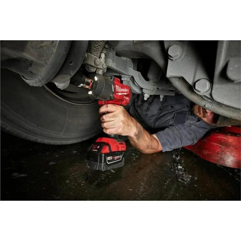 Mechanic using M18 FUEL 1/2 Inch Hi Torque And 3/8 Inch MTIW Automotive Combo Kit Red 3010-22 under vehicle for car repair.