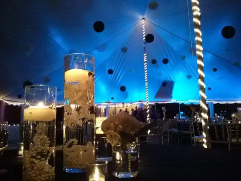 Elegant event setting with Pack Of 4 Wax Flickering LED Floating Candles 3 Inch Tealights Waterproof Warm White Battery Operated.