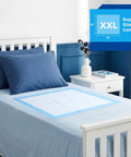 Ultra Thick, Super Absorbent Disposable Bed Pads 30x36 Inches for Adults, Seniors, and Pets on a bed with blue pillows.