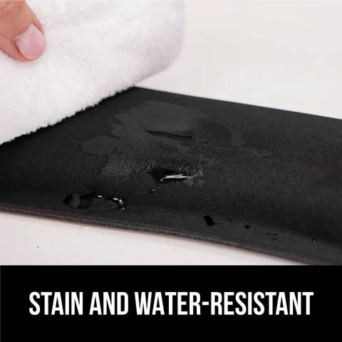 Close-up of black stain-resistant Silky Memory Foam Wrist Rest For Keyboard and Mouse with water and cloth.