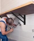 Two Pack Rock Solid Shelf Brackets 16 By 12 Inch Wall Mounted Heavy Duty Floating Support Braces Matte Black Steel Braces installed under a countertop.