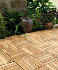 Outdoor patio with 12x12 Inch Solid Wood Interlocking Flooring Tiles Pack Of 9 in Real Acacia Hardwood, surrounded by plants.