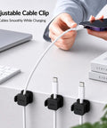 Person using Six Pack Cable Organizer Clips with No Residue Adhesive for neat and tidy desk, holding charger cable securely.