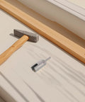 Hex Shank Slotted Wing Nut Socket Wrench For Hurricane Shutters And Panel Nuts positioned beside a hammer and wood.
