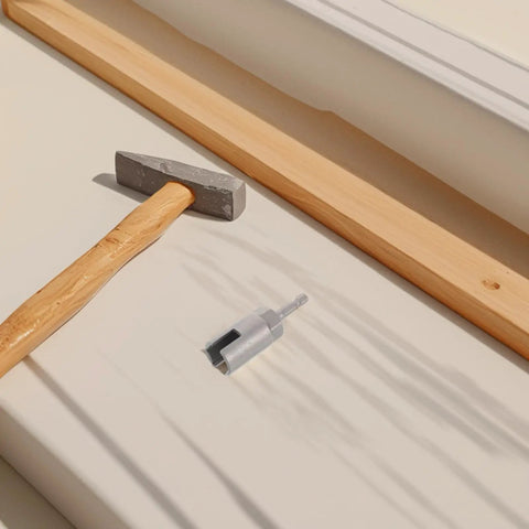 Hex Shank Slotted Wing Nut Socket Wrench For Hurricane Shutters And Panel Nuts positioned beside a hammer and wood.