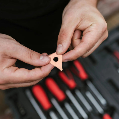 Hands holding part of Durable Dent Pulling Rings for Auto Body and Sheet Metal Repair Kit in front of tool set