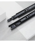 Rock Solid Triple Section Ball Bearing Drawer Slides Built To Last With Cold Rolled Steel, showcasing smooth steel slides lying on a surface.