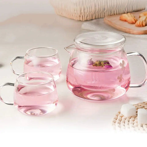 Sleek Heat Resistant Glass Teapot For Cold Brew And Hot Tea with cups featuring pink liquid and floral details.