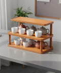 Clean 3 Tier Bamboo Cup Organizer Rack And Sharp Countertop Mug Stand For Coffee Bar Kitchen Office with mugs and teapots.