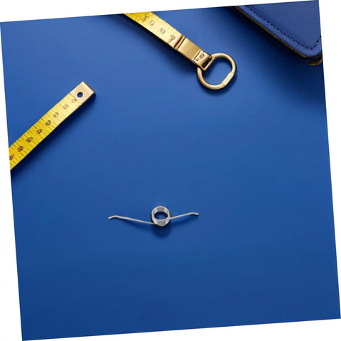 Bulk 20 Pc Torsion Spring Kit For Trash Can Lids With Tiny Iron Nickel Coils, Super Simple Diy Repair And Silent Operation Perfect For Home Maintenance Needs. silver torsion spring on blue background with measuring tape