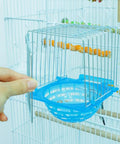4 Pack Slick Bird Hatching Nest Bowls Featuring A Secure Barbed Wire Partition installed in a birdcage with a hand holding it.