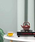 Professional Stainless Steel Coffee Warmer Plate, 80W Electric Mug Heater For Desk And Home with a teapot on a table.
