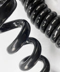 Close-up of coiled section of Built To Last Hardcore 12 Core Coiled Extension Cord featuring black rubber cover.