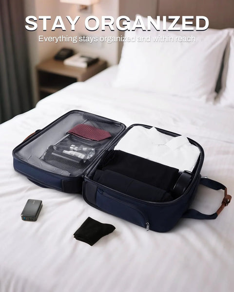 Open navy rolling laptop bag on bed, showing organized compartments for clothes and electronics, ideal for travel and work use