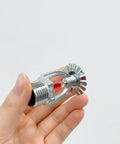 Top Notch Two Pack Fire Sprinkler Heads With Automatic One Fifty Five Degree Fahrenheit Activation For Serious Safety Needs Built Tough For Any Building In A Simple Pendant Down Spray Mount That Handles Extreme Heat Without Breaking A Sweat, showing a hand holding a silver brass sprinkler head with red sensor.