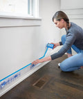 Person applying DIY Ready Pre Plastic Painters Tape With Bladed Dispenser 24 Inch By 30 Yard All In One Tape And Masking Film System