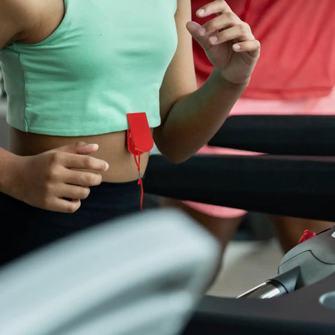 Person using treadmill with red Treadmill Safety Key With Magnet Lock Replacement Kit clipped to waist
