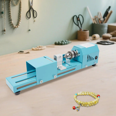 This Badass Mini Wood Lathe Is The Ultimate Desktop Turnin' Tool For Your DIY Crafts on a workbench with beads.