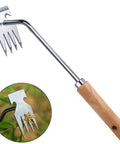 Four Tine Stainless Steel Weed Puller Tool With Solid Wood Handle for backyard planting, shown in use, sturdy design.