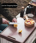 Person cutting lemon on Heavy Duty Collapsible Storage Bins With Lid, Tough Camping Organizer Box For Car Trunk And Groceries.