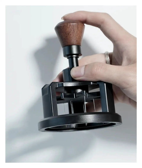 Heavy Duty 58 Millimeter Espresso Portafilter Needle Distributor With Built In Magnet, hand holding tool for coffee ground preparation.