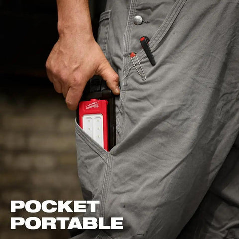 Person placing Low Profile Magnetic Task Light With Three Modes High 500 Lumens in grey pocket, showcasing portability.