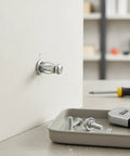 Hollow Wall Anchors M4 x 20mm Kit with Iron Expansion Bolts in drywall, visible in installation process, for shelves and mirrors.