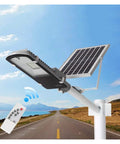 Badass Outdoor Solar Security Flood Lights With Remote Control And Adjustable Bracket on a pole near a road with blue sky.