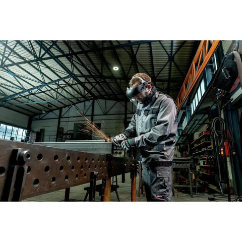 Worker using 4.5 To 5 Inch Angle Grinder Beast With Lock On Switch, 11 Amp, 11,000 RPM on metal in industrial workshop.