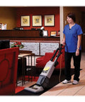 Heavy Duty Bagged Upright Vacuum Cleaner With Dual Motor Suction And HEPA Media Filtration commercial grade in use by a cleaning professional.