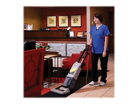 Heavy Duty Bagged Upright Vacuum Cleaner With Dual Motor Suction And HEPA Media Filtration commercial grade in use by a cleaning professional.