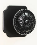 Close-up of 9 Pack Matte Black Cabinet Knobs 1.25 Inch Round Zinc Pulls With Victorian Floral Pattern For Farmhouse Kitchens.