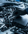 Hand in a black glove installing a bolt from the Top Shelf 14 Pc Engine Under Cover Hardware Kit on Honda engine components.