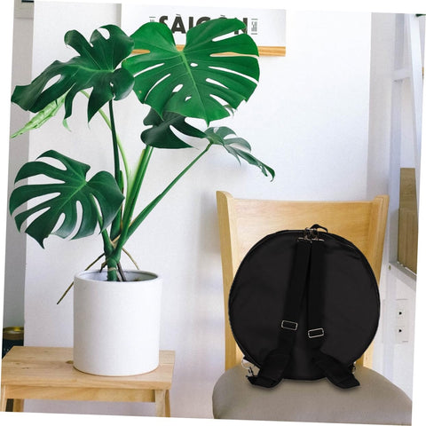 Heavy Duty Adjustable Drum Backpack With Massive Capacity Oxford Fabric Waterproof Gig Bag on a chair next to a plant.