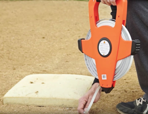 Person measuring baseball field with NRS18M330 Nylon Reinforced Tape Measure With Beast Speed Rewind And Double Hook 100M 330FT
