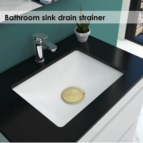 Gold Stainless Steel Shower Drain Catcher With Soft Silicone Edge Flat Round Tub Strainer in a white bathroom sink.