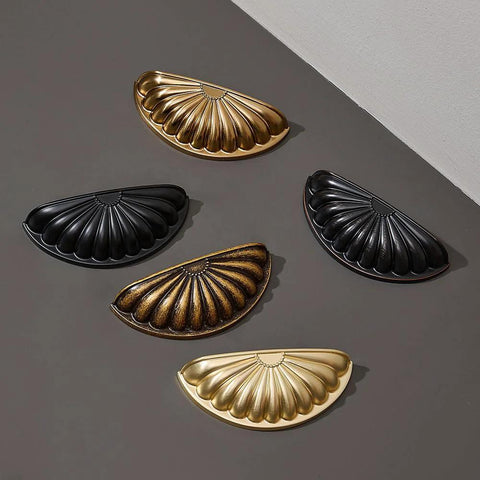 5 decorative drawer handle shells in gold and black finishes, showcasing detailed textures and antique style.