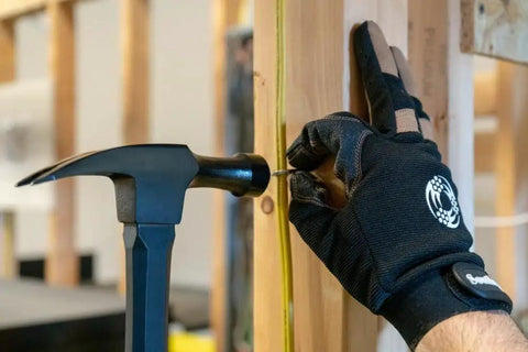 18 Oz Electrician Hammer With Extended Neck For Tight Spaces, Romex Staple Remover, in use with gloved hand in construction setup